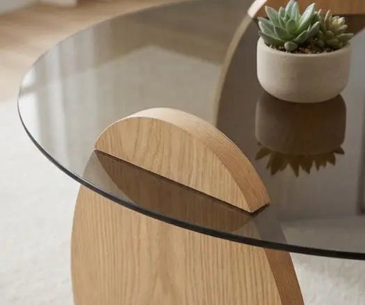 Glass coffee table with wooden legs and a small potted plant on a light background