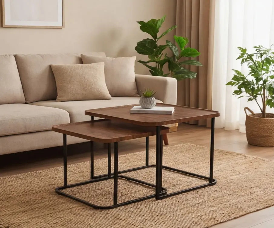 Nest of wooden tables in a living room setting with a beige sofa and plants.